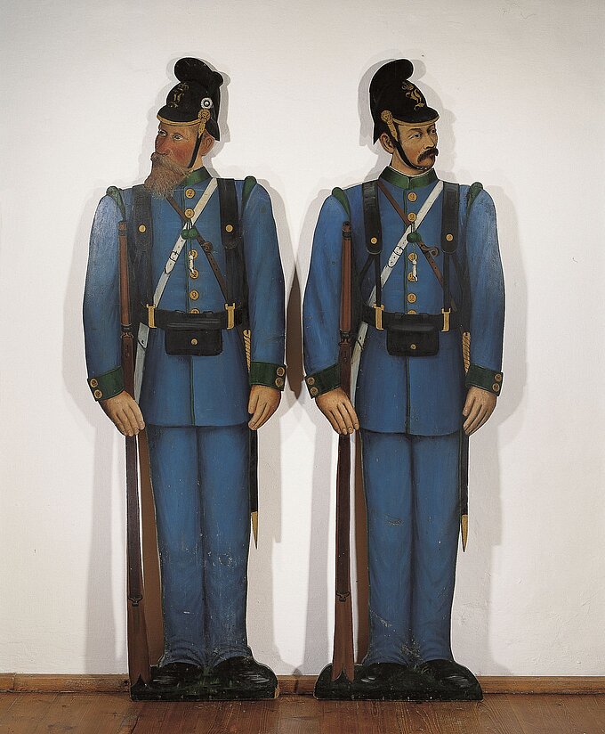 Darstellung zweier historischer Wachsoldaten in historischer blauer Uniform.